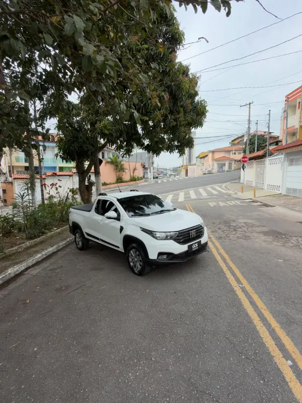 Fiat Strada Freedom branca, frente em três quartos, parada na rua